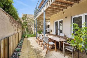 an outdoor patio with a wooden table and chairs at Willos in Queenscliff