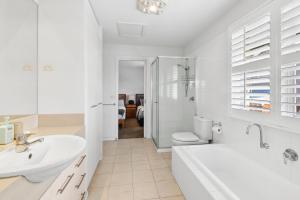 a bathroom with a tub and a sink and a toilet at Willos in Queenscliff +13 photos
