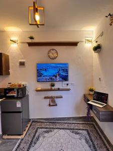a room with a clock and a laptop on a wall at Homes by Najma in Mtwapa