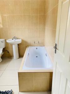 a bathroom with a bath tub and a sink at Smileys accomodation in Standerton