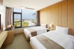 a hotel room with two beds and a large window at Royal Emporium Incheon Airport in Incheon +60 photos