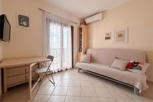 a living room with a couch and a desk and a window at Petra Afytos holiday in Afitos