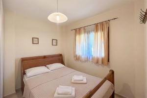 a bedroom with a bed with two towels on it at Petra Afytos holiday in Afitos