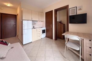 a kitchen with a white refrigerator and a table at Petra Afytos holiday in Afitos