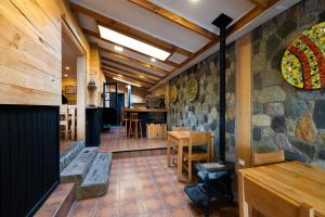 a room with a stone wall with a table and chairs at Hotel Aquaterra in Puerto Natales