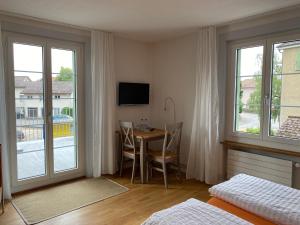 a bedroom with a table and a room with a window at Hopfengrün Langenthal in Langenthal