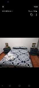 a bedroom with a bed with a black and white comforter at Casa Sauces in Tepoztlán +8 photos