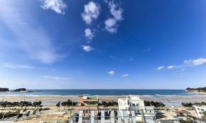 a view of a beach with a building and the ocean at Taean Manripo Feel Hotel in Taean