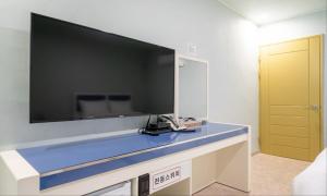 a bathroom with a large tv on the wall at Taean Manripo Feel Hotel in Taean