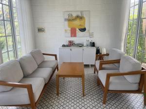 a living room with a couch and two chairs and a table at Perolas Homestay in Xóm Chum Găng
