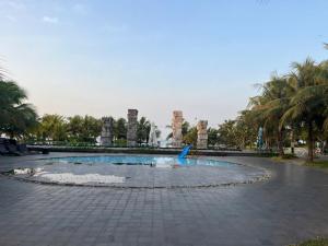 a fountain in the middle of a courtyard with palm trees at Perolas Homestay in Xóm Chum Găng +7 photos
