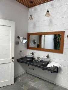 a bathroom with two sinks and a mirror at Perolas Homestay in Xóm Chum Găng