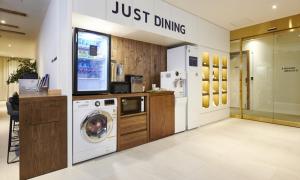 a laundry room with a washing machine and a tv at JustSleep Namyangju Dasan in Namyangju