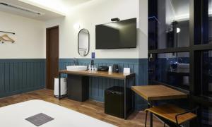 a bathroom with a sink and a tv on the wall at JustSleep Namyangju Dasan in Namyangju