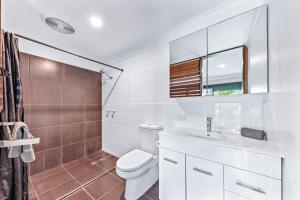 a bathroom with a toilet and a sink and a mirror at Seascape Paradise in Airlie Beach +24 photos