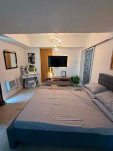 a large bedroom with a large bed and a flat screen tv at Azure North MiCasa in San Fernando +20 photos