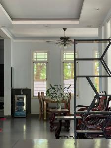 a living room with a ceiling fan and a table and chairs at Vy Home in Thanh Ðông (1)