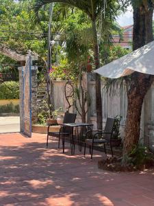 a patio with a table and chairs and a tree at Vy Home in Thanh Ðông (1)