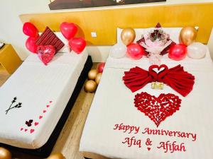 two twin beds with balloons and a happy anniversary sign at Delta Chenang Resort in Pantai Cenang