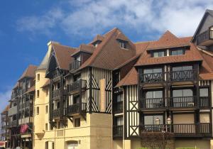 un grand immeuble avec un toit brun dans l'établissement Mercure Deauville Centre, à Deauville