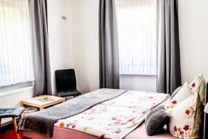 a bedroom with a bed and a chair at Pension Andries in Ernst