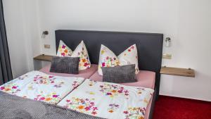 a bedroom with a pink bed with pillows at Pension Andries in Ernst