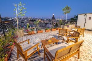 a patio with chairs and tables and a view of the city at El Khan Guesthouse & Art - A Complex of 4 Middle Eastern-Style Suites in Nazareth
