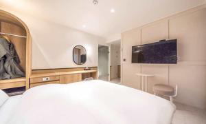 a bedroom with a white bed and a tv on the wall at HOTEL STAY AYANA DAEJEON in Daejeon