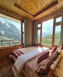 a bedroom with a bed with a view of a mountain at The Sunflower Homes in Gondla