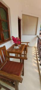 a room with two benches and a table with flowers on it at Hilias Retreat in Palolem +23 photos