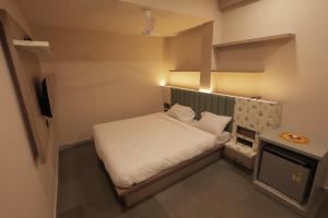 a small bedroom with a bed in a small room at Hotel Best Inn in Valsād