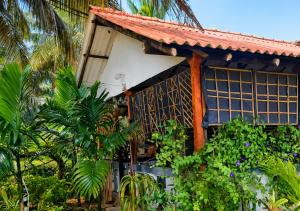 a house with a red roof and some plants at DA GREA NATURAL BEACH HOTEL in Trincomalee
