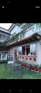 a patio with tables and chairs in front of a building at Casa Sauces in Tepoztlán