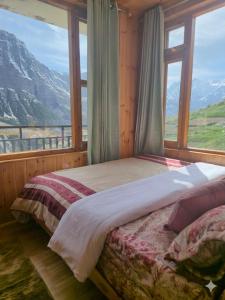 a bedroom with a bed with a view of a mountain at The Sunflower Homes in Gondla +30 photos