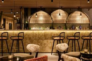 Eine Bar mit Hockern in einem Raum mit einer Theke in der Unterkunft The Cloud One Lisbon in Lissabon