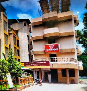 a building with a red sign on the side of it at HOTEL SHRI PUSHPANJALI SHIRDI in Shirdi