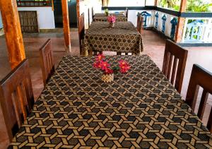 a dining room with two tables with flowers on it at DA GREA NATURAL BEACH HOTEL in Trincomalee