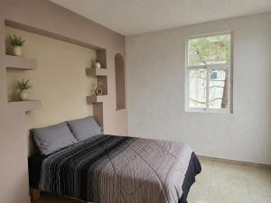 a bedroom with a bed and a window at CABAÑAS SANAMBO fraccionamiento los gallos in Balastre Rojo
