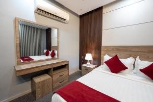 a hotel room with a bed and a mirror at راحتي هنا للشقق المخدومة 7 in Riyadh