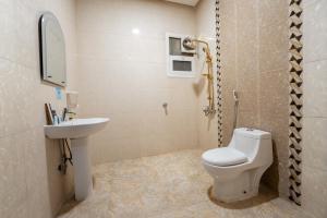 a bathroom with a toilet and a sink at راحتي هنا للشقق المخدومة 7 in Riyadh +23 photos