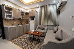 a living room with a couch and a table and a kitchen at راحتي هنا للشقق المخدومة 7 in Riyadh