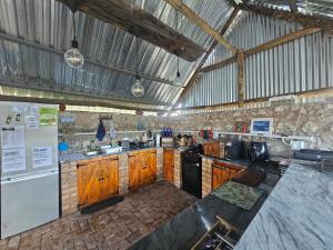 a large kitchen with wooden cabinets and a refrigerator at Tamboti Farm Self-Catering Accommodation in Tsumeb