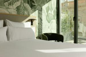 ein Schlafzimmer mit einem Bett, einem Stuhl und einem Fenster in der Unterkunft The Cloud One Lisbon in Lissabon