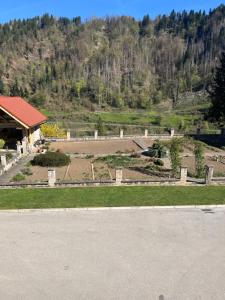 a garden in front of a building with a mountain at Apartmaji pri Mojci in Podvelka
