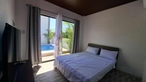 a bedroom with a bed and a large window at Isla Del Mar Villas in Panglao Island +56 photos