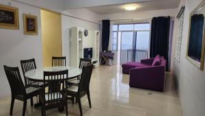a living room with a table and chairs and a couch at The Gladiator Homstay in Brinchang