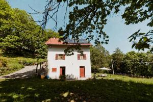 a small white house with a red roof at La perla nella foresta in Vara Superiore