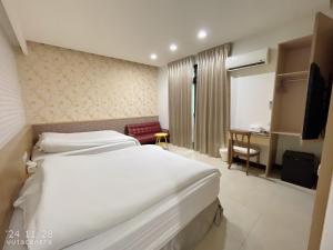 a hotel room with two beds and a desk at Shiyue Homestay in Zhuangwei
