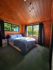 a bedroom with a bed in a wooden cabin at Ruapehu Farm Chalet in Ohakune