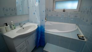 a bathroom with a sink and a bath tub at Kun Kuckó Vendégház in Kiskunmajsa +25 photos